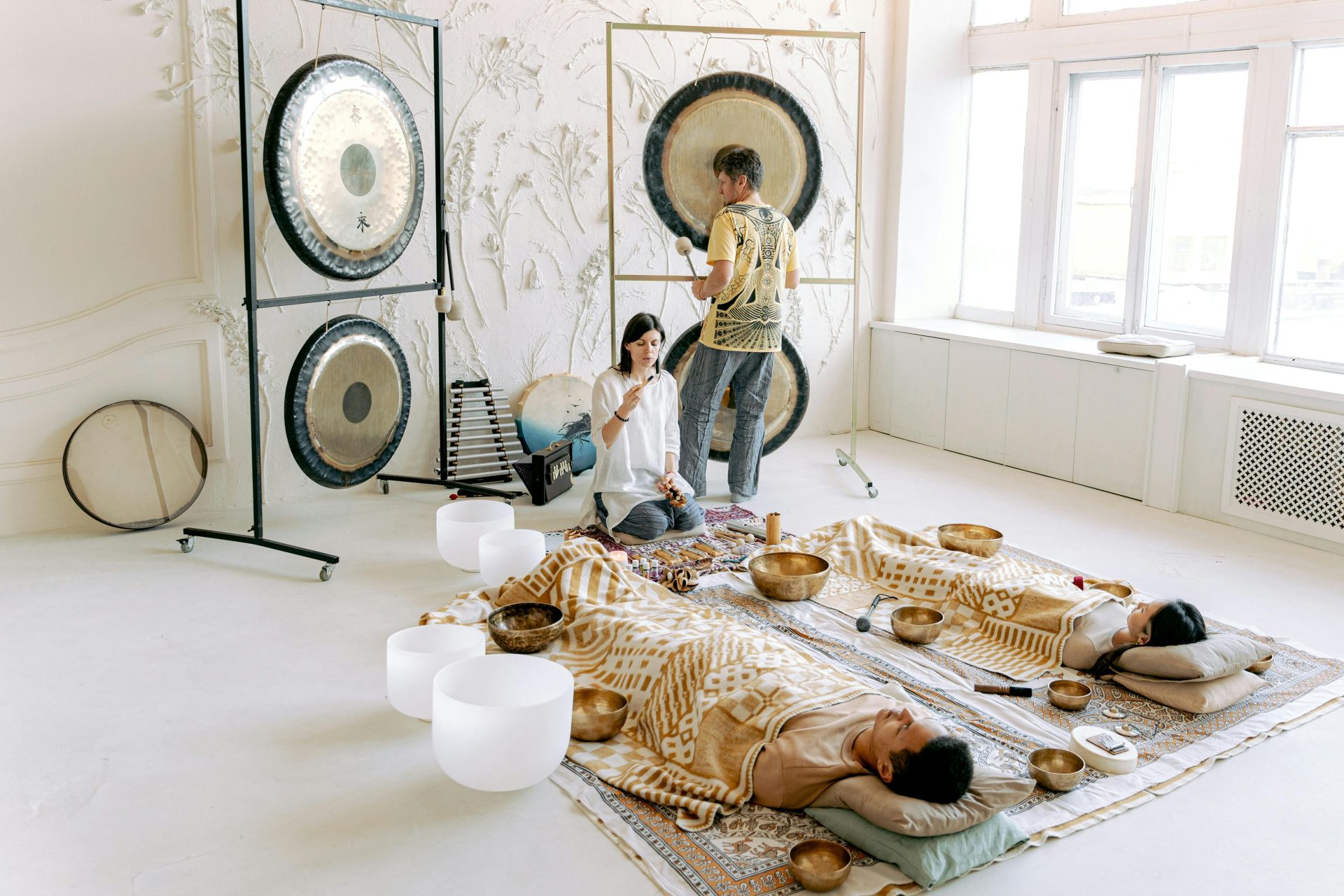 A serene indoor sound bath session with gongs and singing bowls promoting relaxation and wellness.